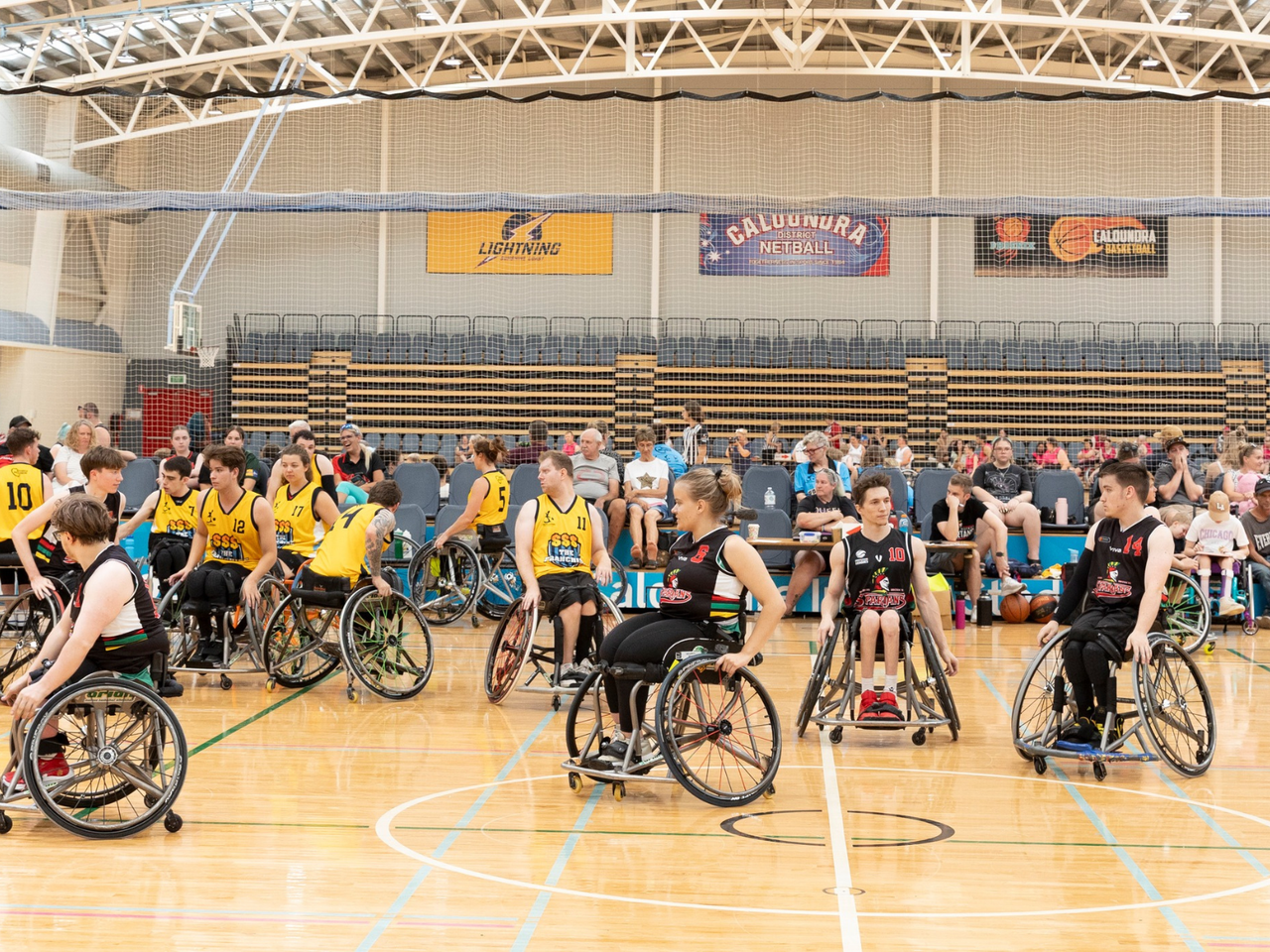 A number of wheelchair basketball players on court