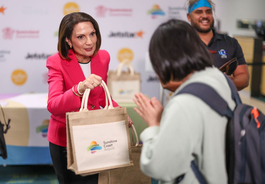 Mayor Rosanna Natoli handing out a goody back to a passenger who arrived on the inaugural Jetstar flight from New Zealand to Sunshine Coast.
