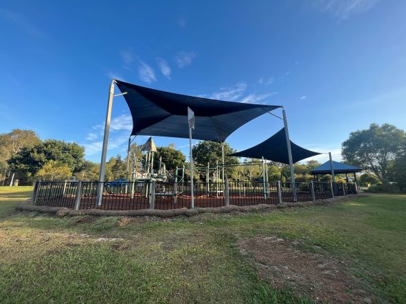 Fenced playground with shade structure