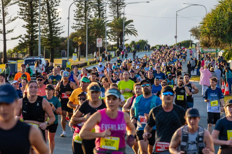 Hundreds of marathon runners - running towards the camera along a main road