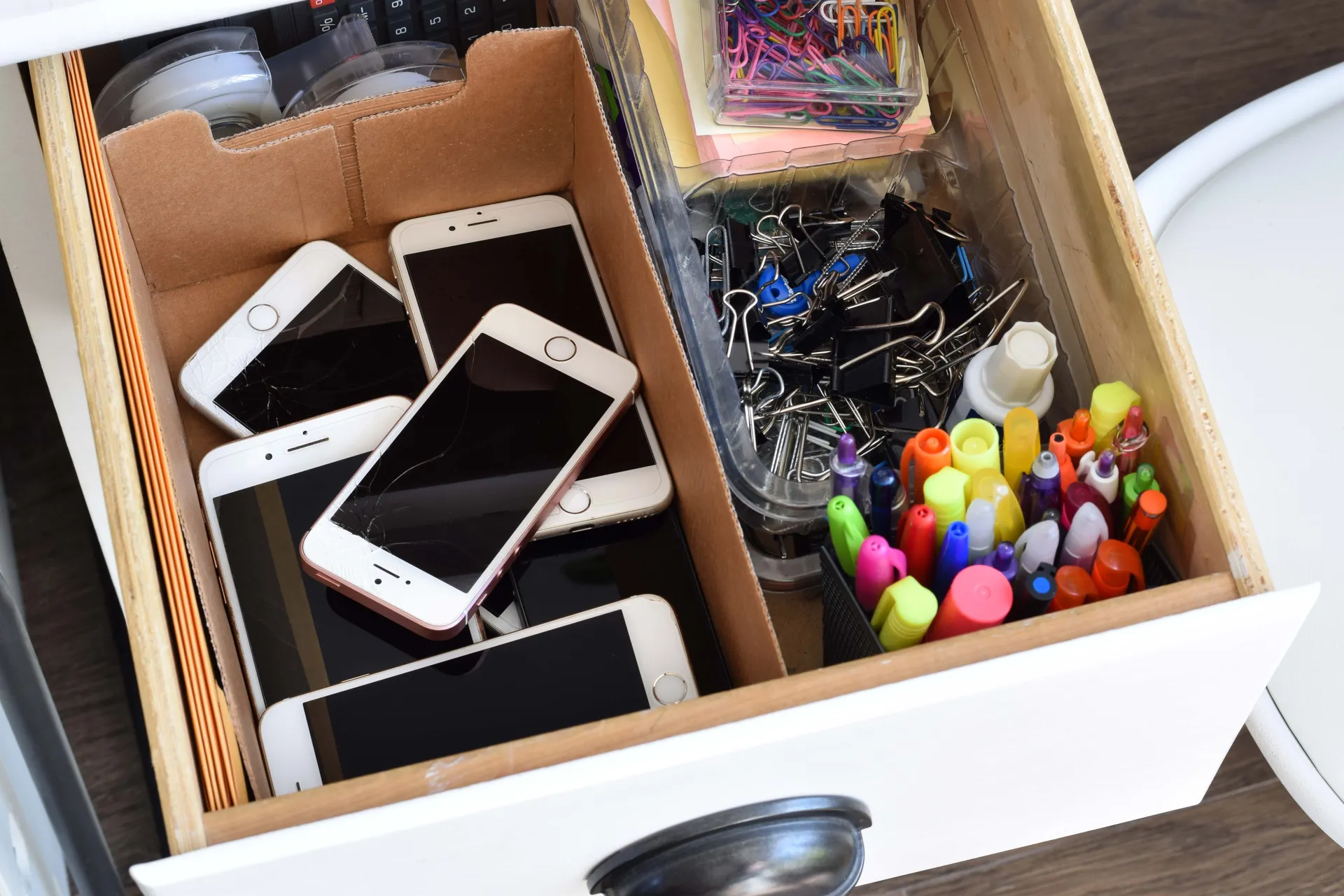 iphones and stationery in a drawer
