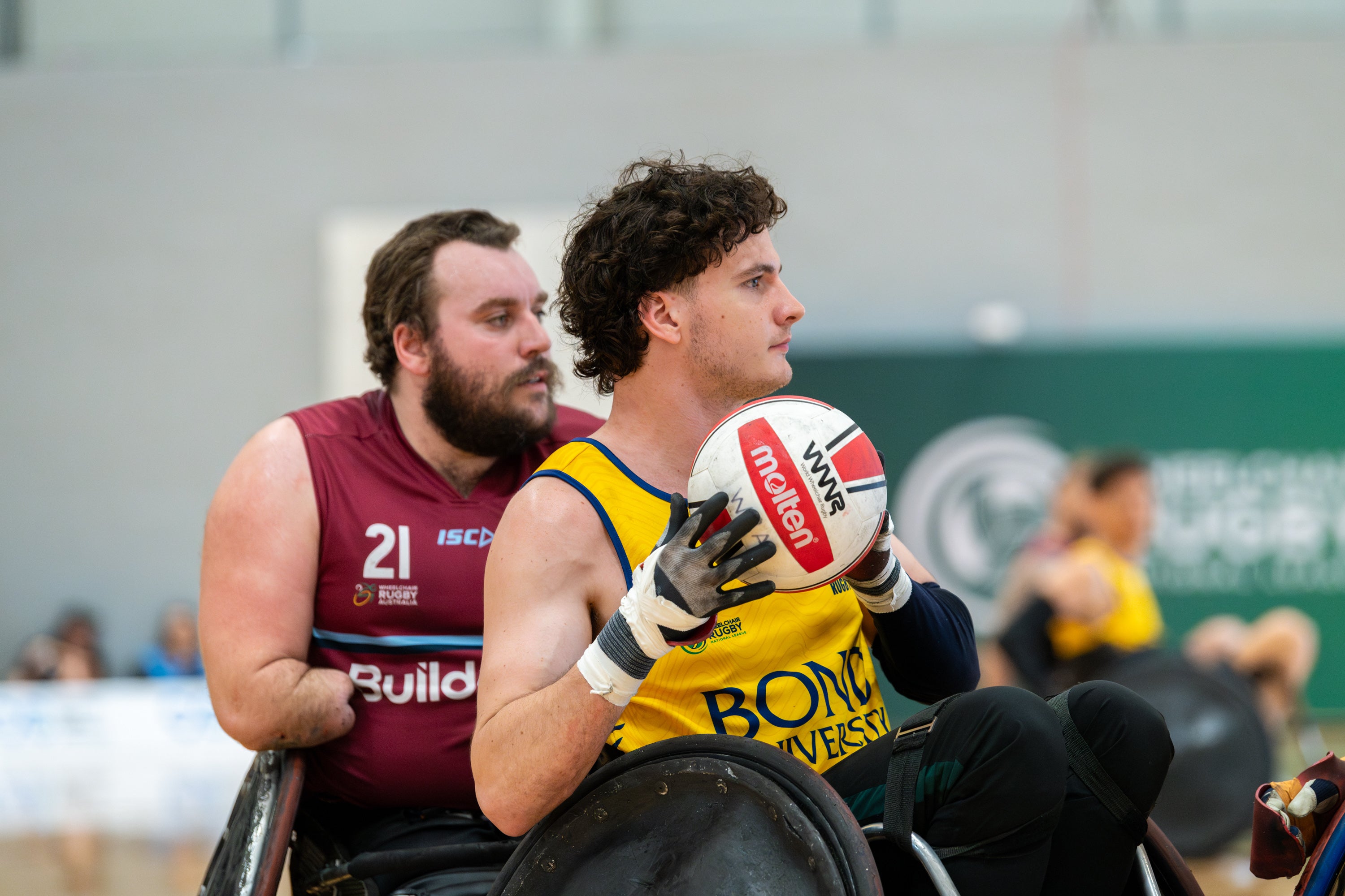 Two parasport athletes with the front player holding the ball.