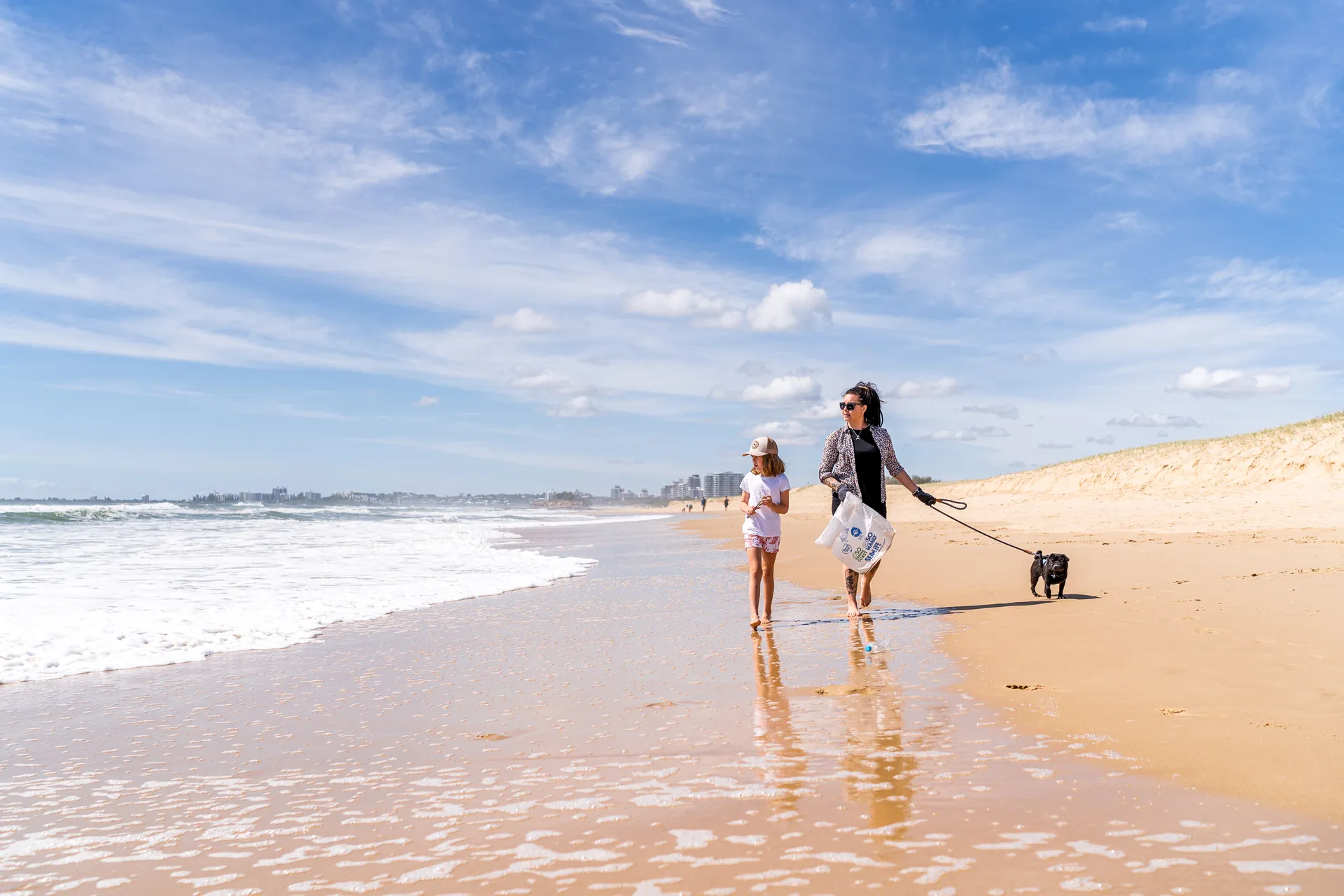 A family walks Mudjimba Beach. 