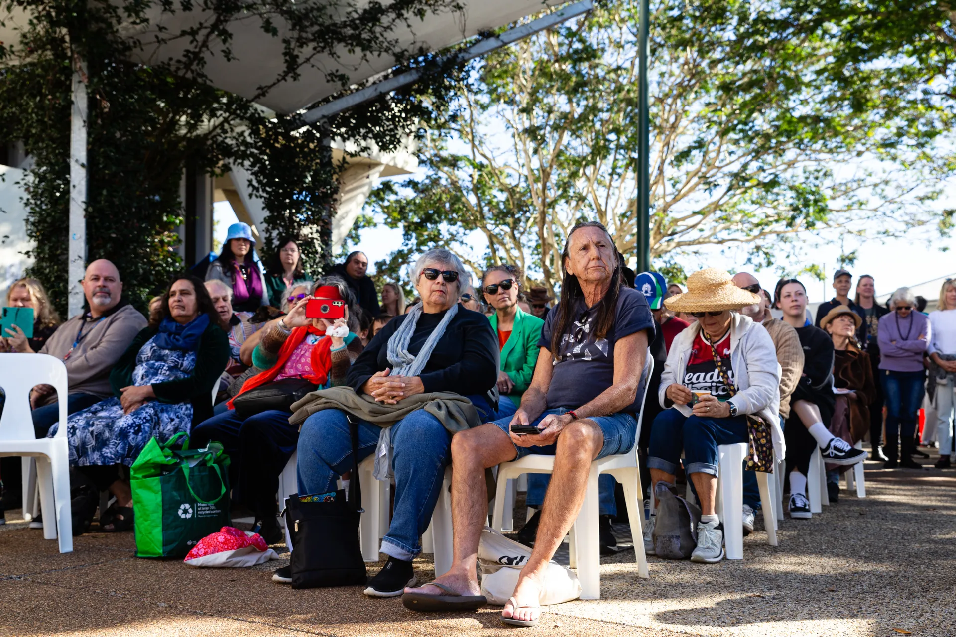A crowd of people sit waiting for the official proceedings to begin.