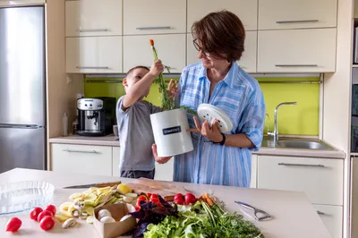 Child helping to compost in the kitchen