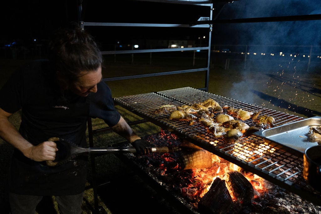 Chef working over a fire oven