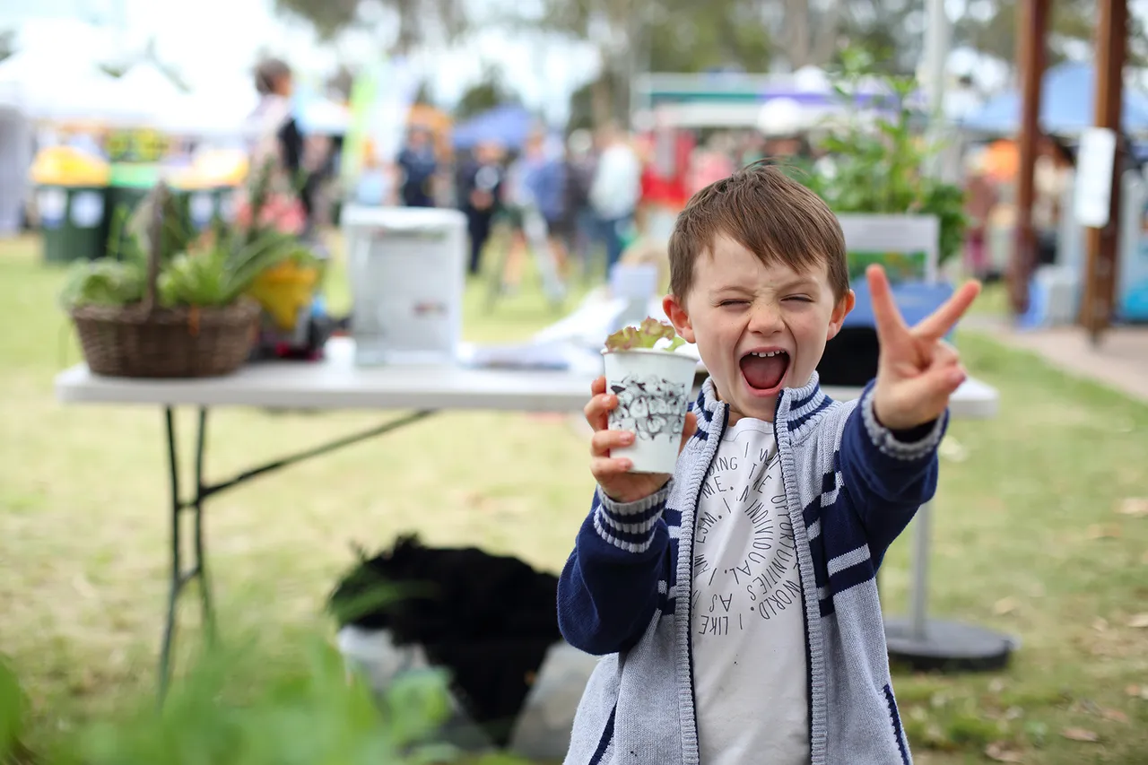 Young boy with a plant in pot