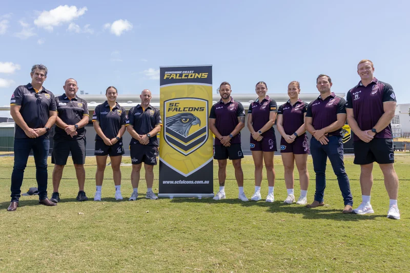 A group of people from the Sunshine Coast Falcons club and Broncos representatives. 4 people standing on the left hand side of a Falcons branded vertical banner and 5 people standing to the right.