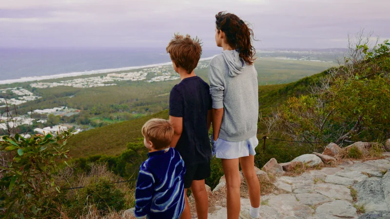 Group of children standing on Mount Coolum observing the afternoon view of the ocean
