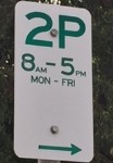 Timed parking sign with days and times with green arrow pointing right.
