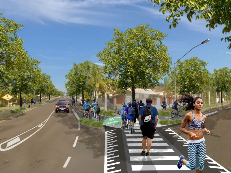 Artist impression of a Goonawarra Drive with a raised zebra crossing, green cycle lane, cyclists riding along the path, pedestrians walking nearby, and trees lining the road under a clear blue sky.