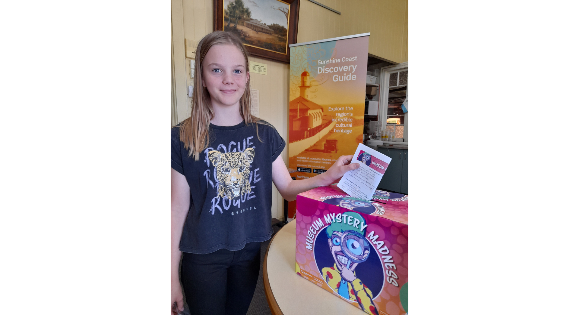 Young girl with discovery guide sign in the background