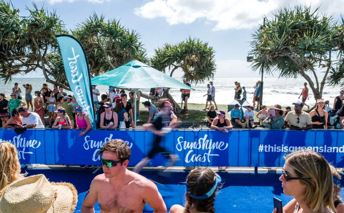 Sidelines at the Mooloolaba Tri with people watching an athlete run by.
