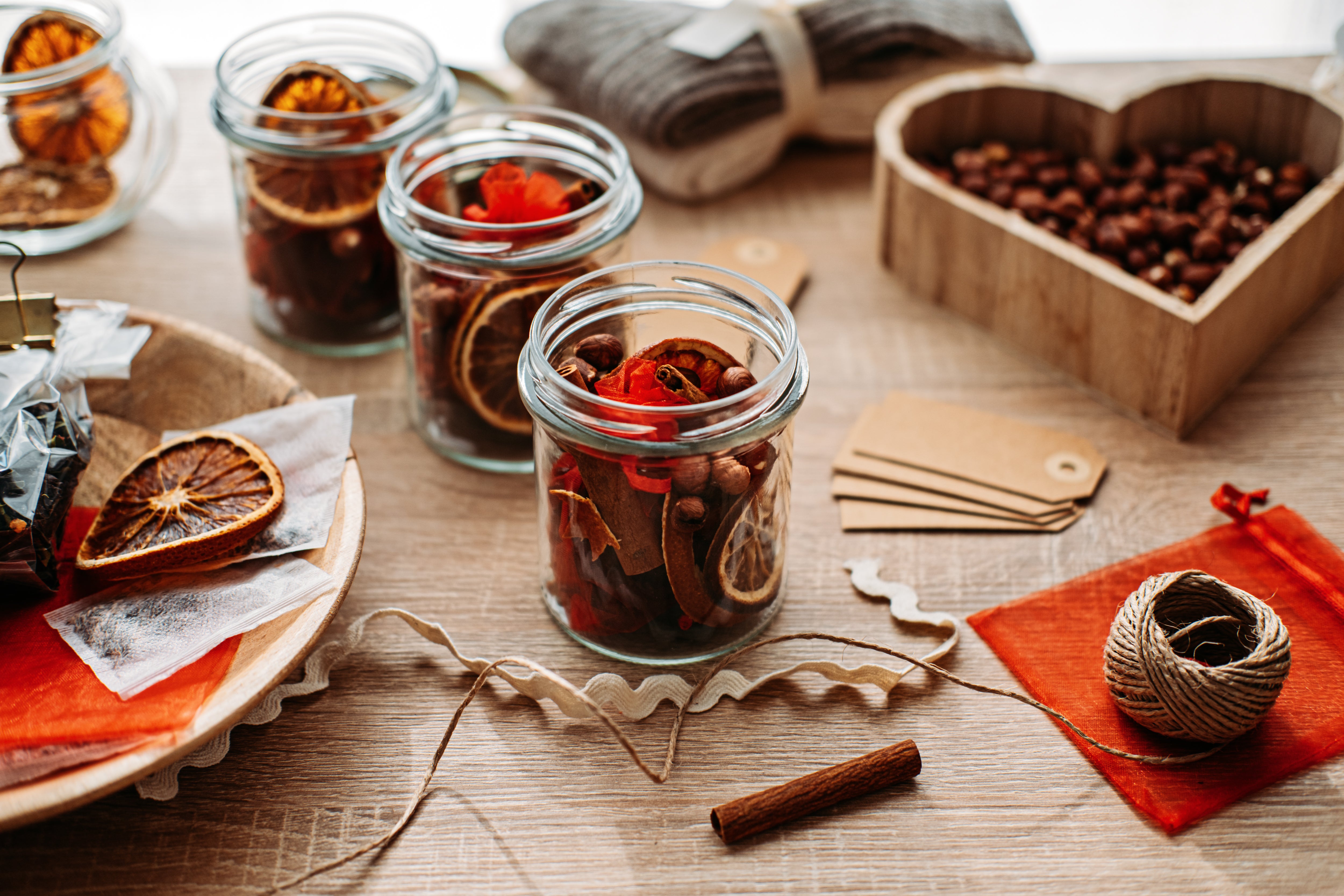 dried orange and seeds in glass jars, ready to be decorated with natural materials