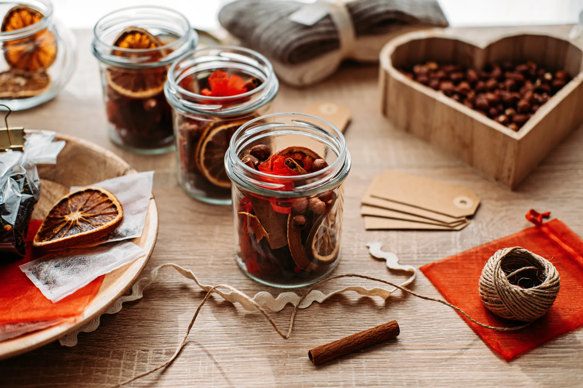 dried orange and seeds in glass jars, ready to be decorated with natural materials