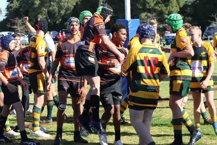 A number of junior rugby players on field.