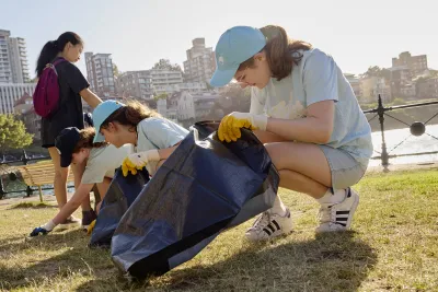 Clean up Australia Day image of young women collecting rubbish along a waterway park