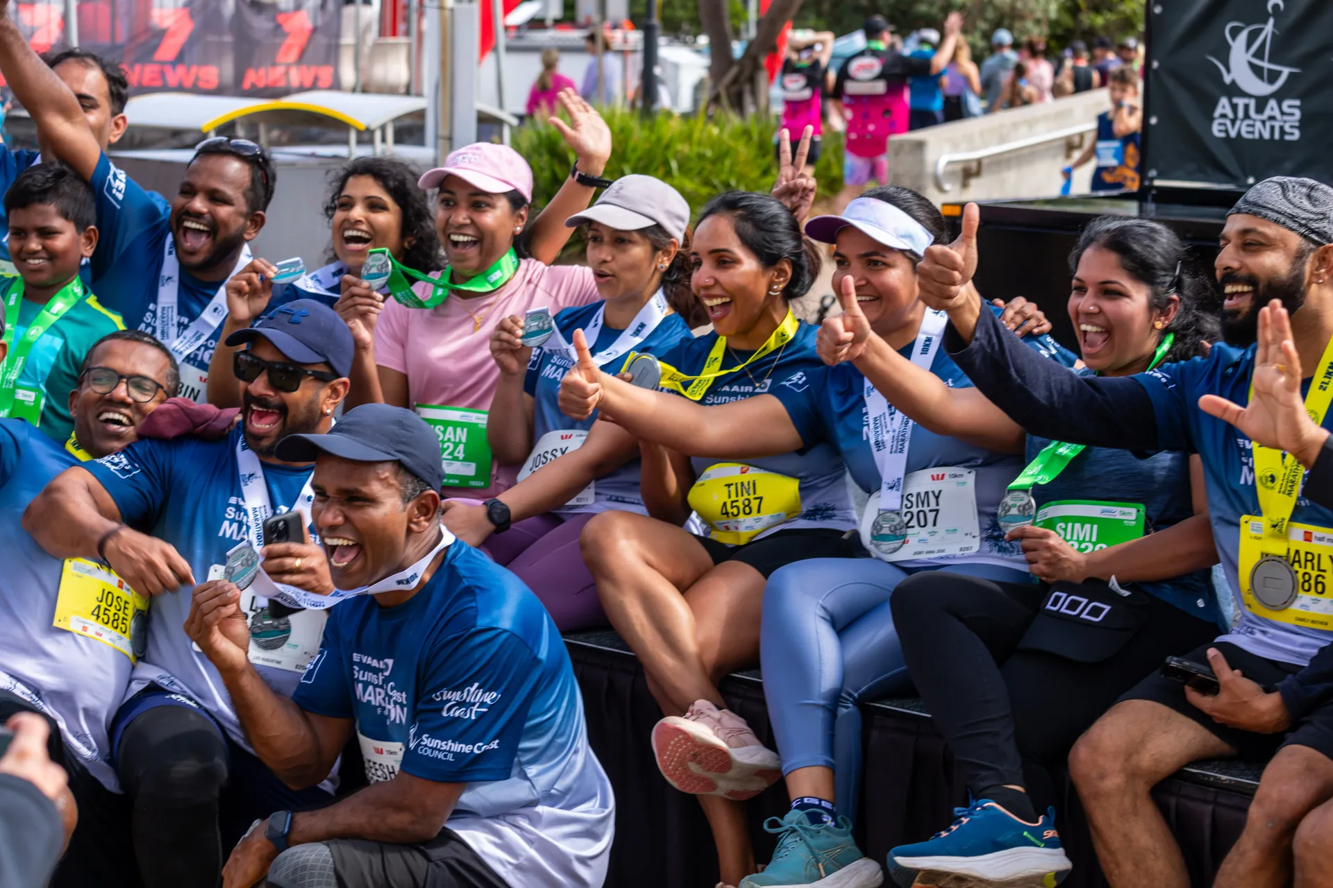 A group of marathon participants holding up their medals or giving a 'thumbs up'