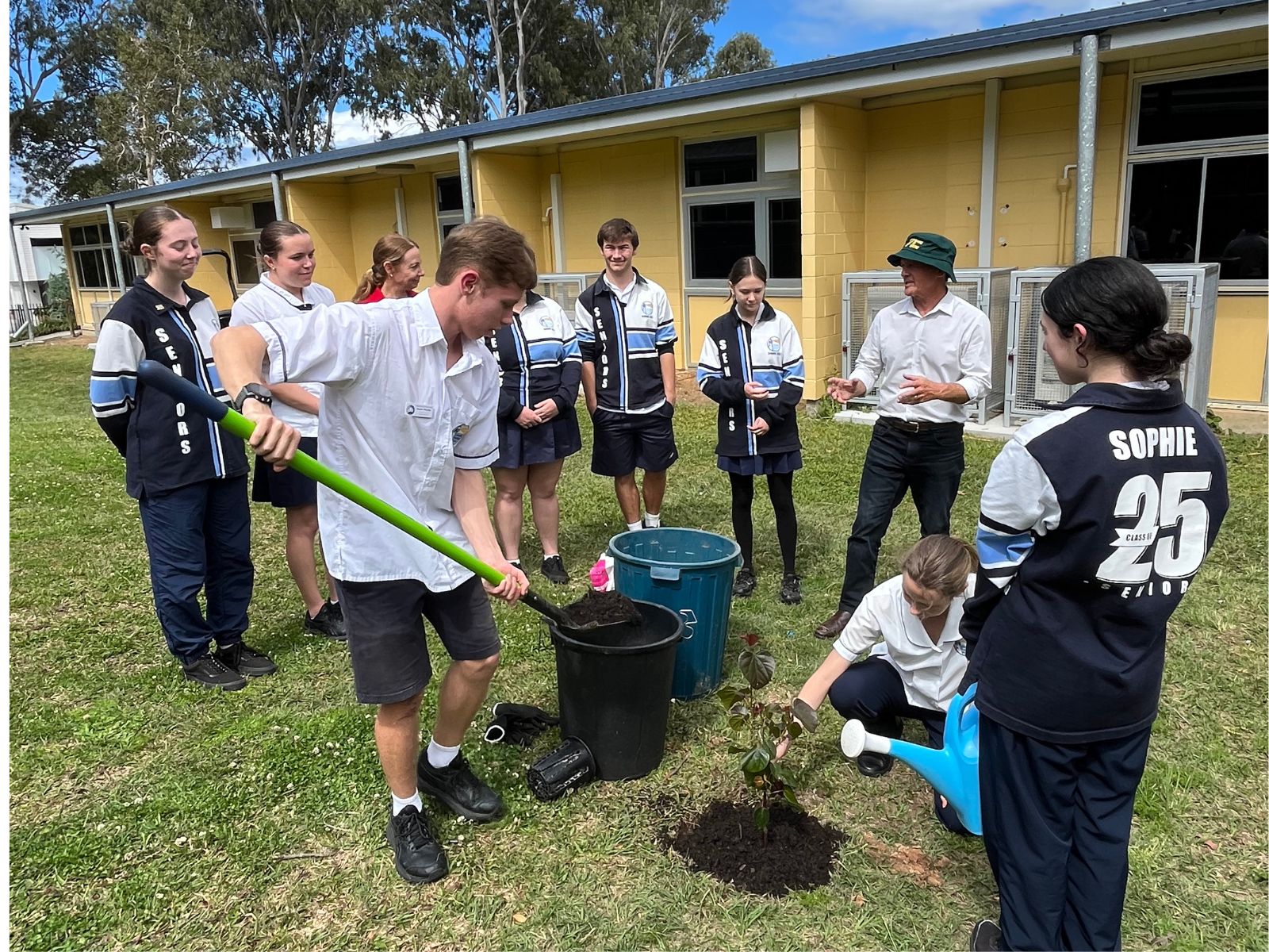 Students digging Caloundra State High School and planting a tree. 