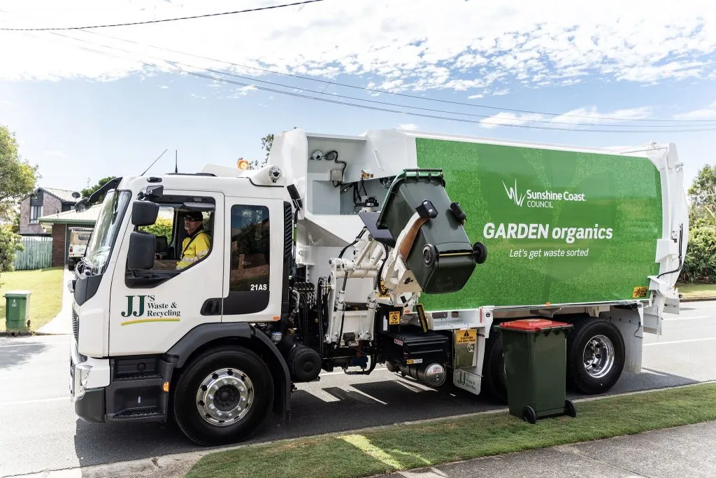 JJ Richards truck serving green organics bin on a residential street.