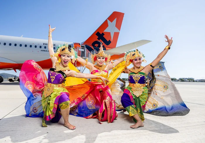 Balinese dancers posting in front for a Jetstar plane.