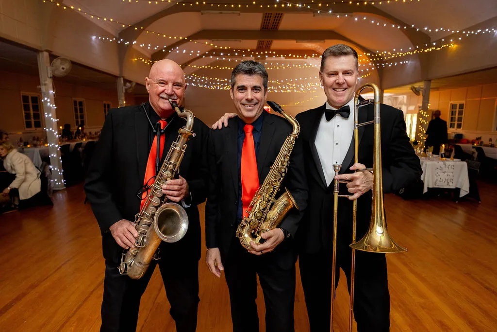 Three gentlemen musicians two holding saxaphones, the last a trombone