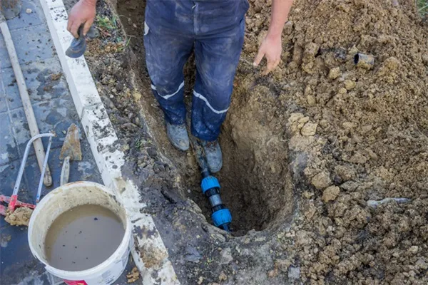 Plumber fixing water leak in pipe underground
