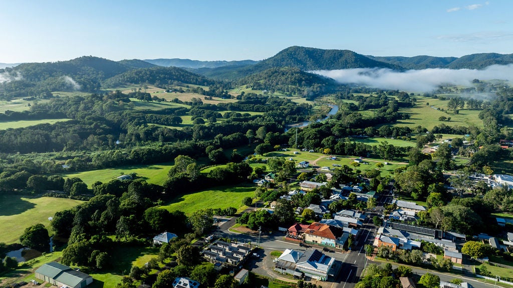 A landscape view of the town of Kenilworth on the Sunshine Coast. Lots of dark green trees and lower left houses and businesses.