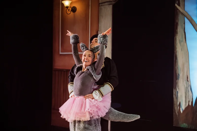 Prima ballerina dressed as a kangaroo in a pink tutu dancing joyfully