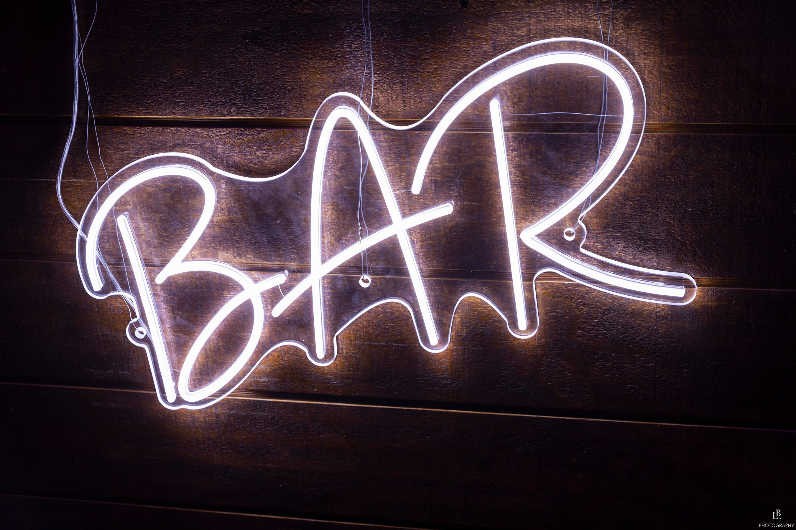 image of a brick wall with a fluoro light reading 'BAR'