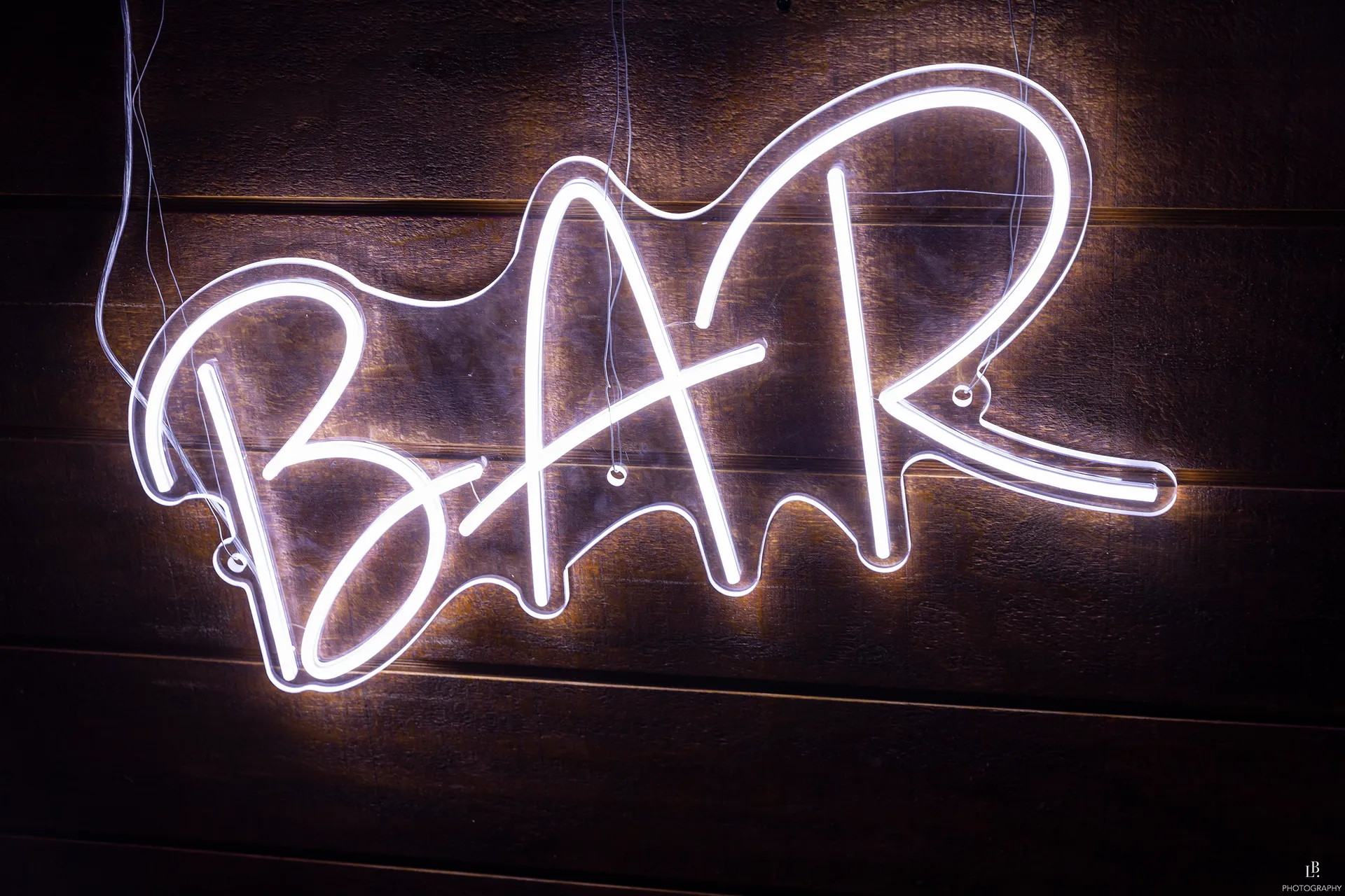 image of a brick wall with a fluoro light reading 'BAR'