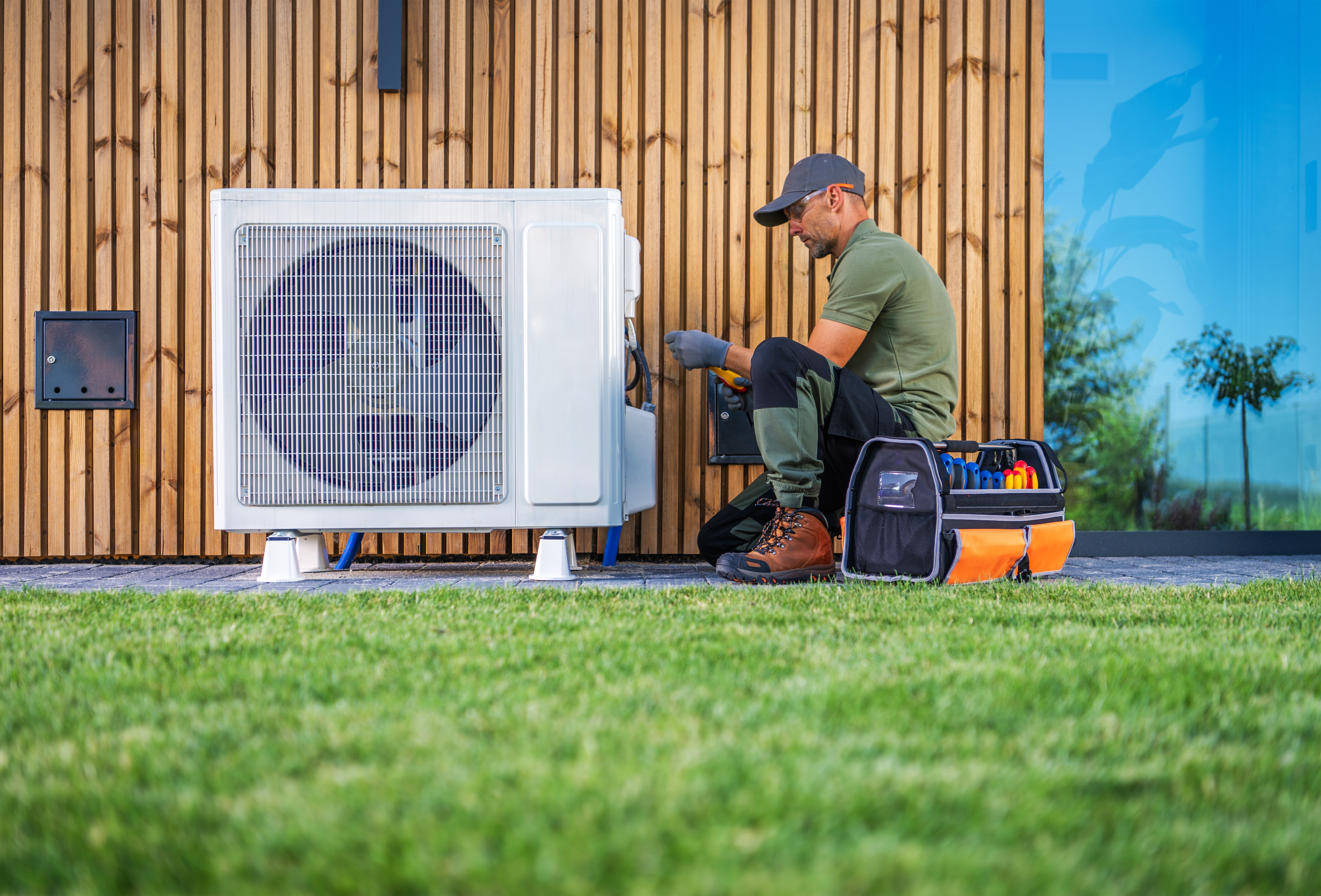 professional air conditioning service man inspects outdoor unit