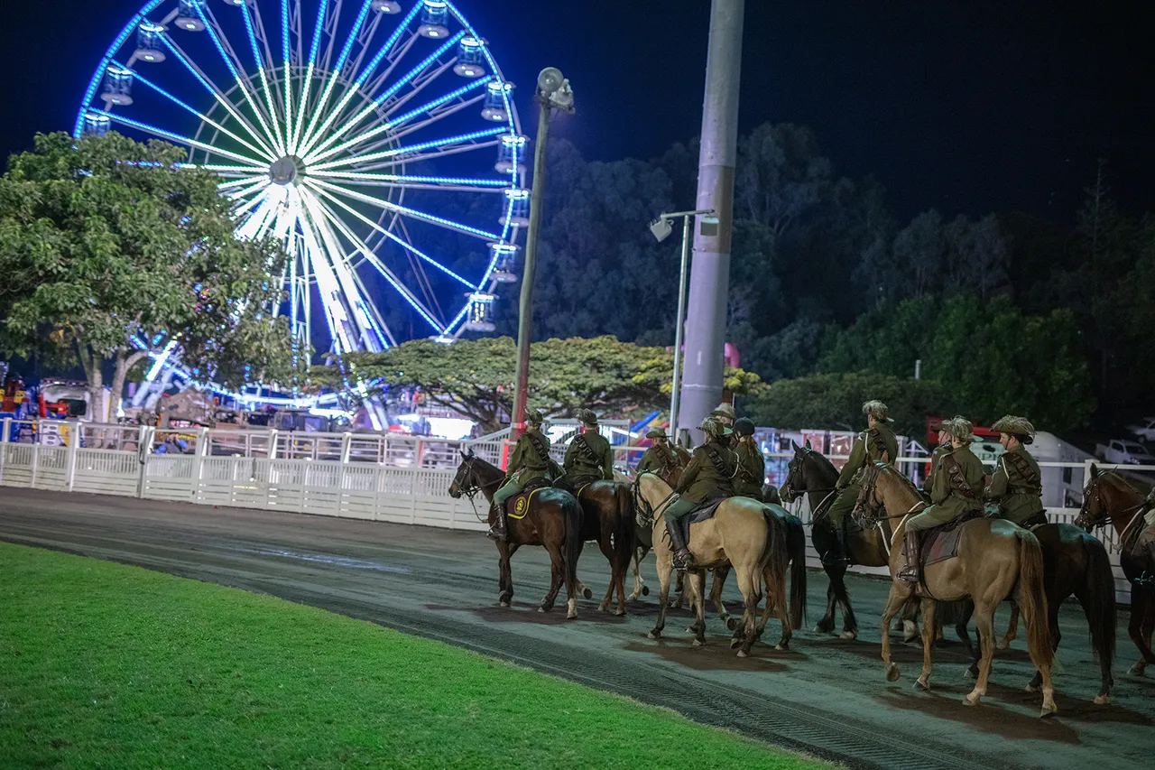 The ferris wheel lights in the background, and the light horse brigade at the front right