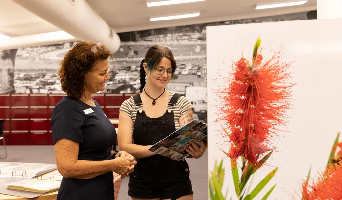 Two people sharing their love of libraries looking at a book. 