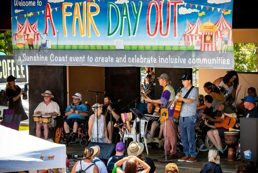People watching a band on stage, with a big banner at the top - A Fair Day Out