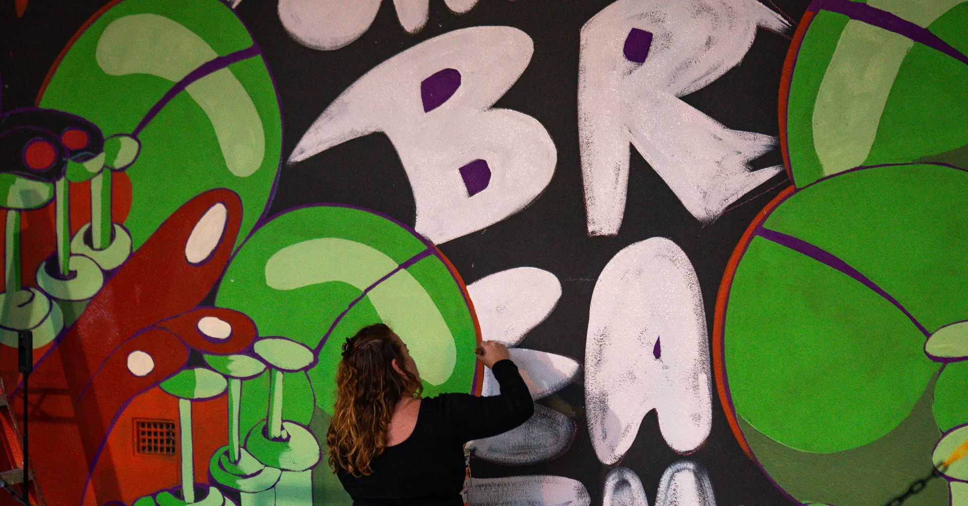 Alison Mooney painting a mural