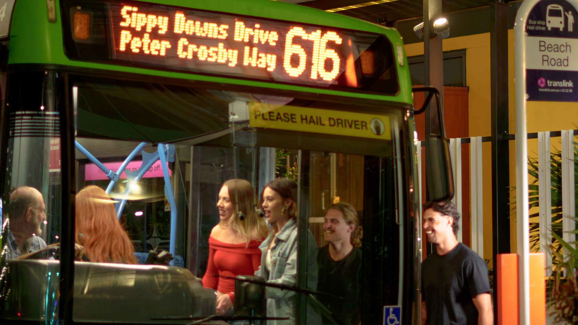 Bus 616 pulling up to collect passengers at night time. 