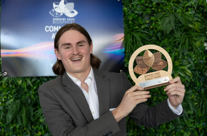 Kurt Jones stands with the award trophy