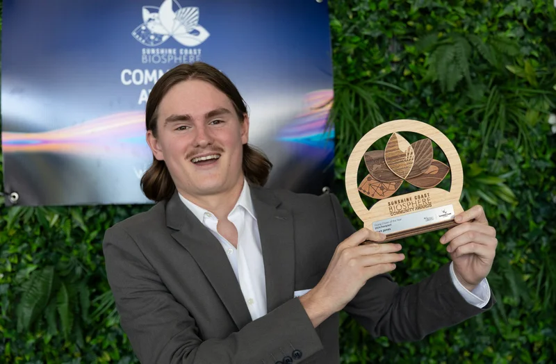 Kurt Jones stands with the award trophy