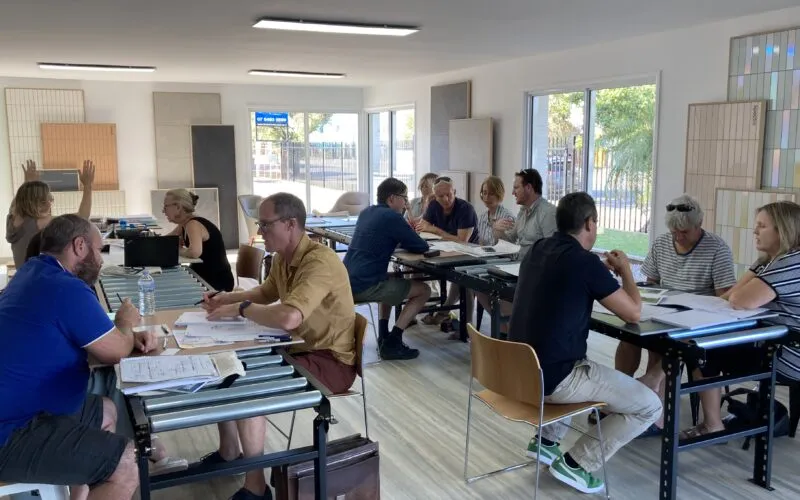 ask an architect session. image shows architects sitting at tables discussing plans with members of the public.