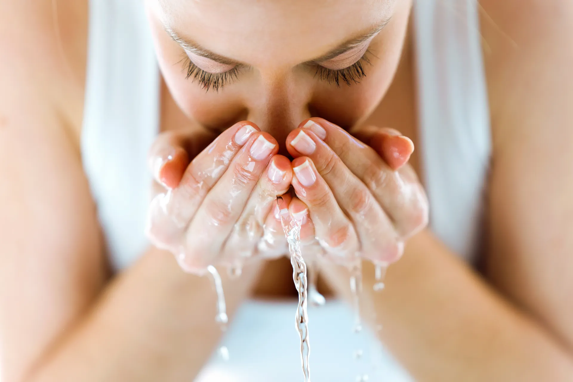 Image shows a lady washing her face