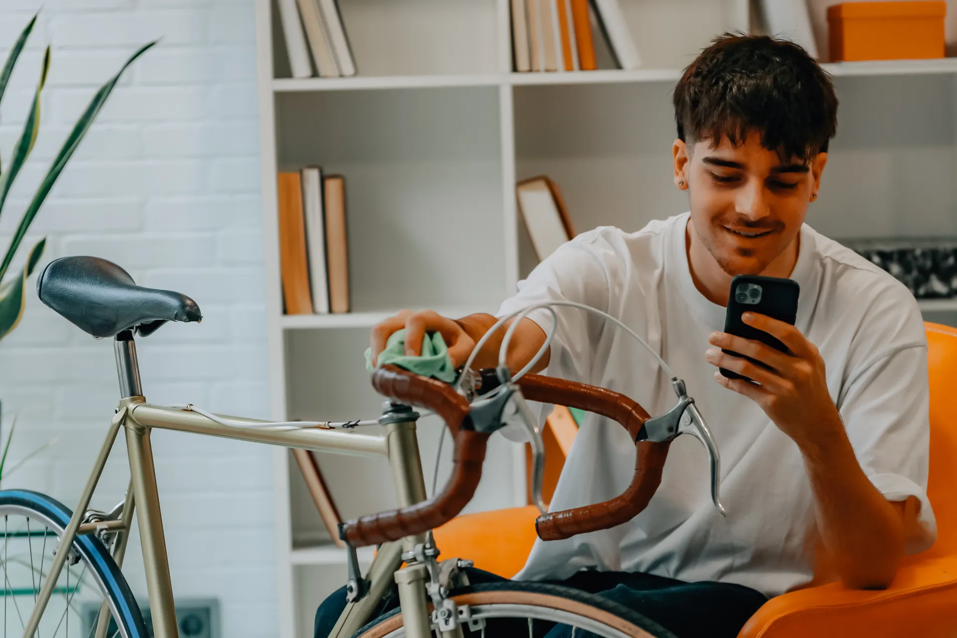 Young man cleaning his bike with a rag