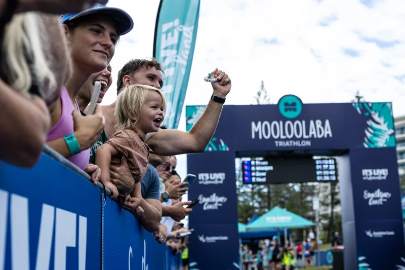 Spectators cheering on athletes through the finish chute of the Mooloolaba Triathlon