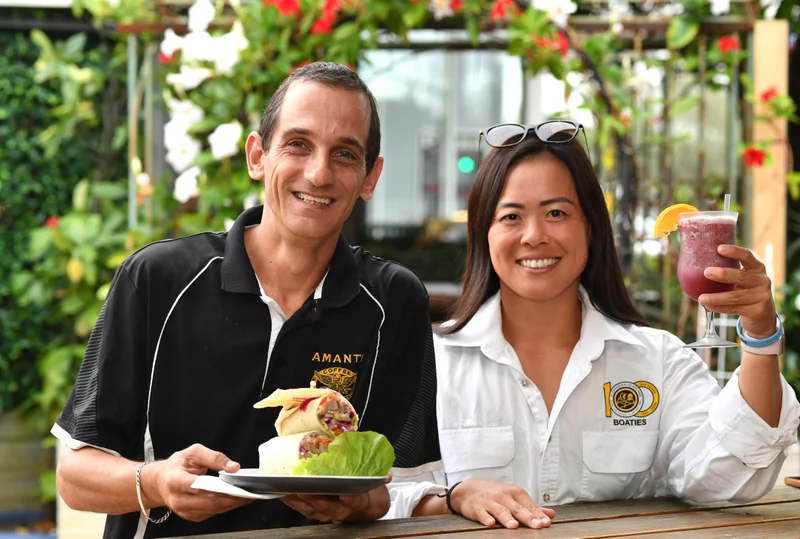 Black Bunny Café owner Glen Elliott serves surfboat rower and Aussies competitor Asako Ono from Alexandra Headland Surf Club