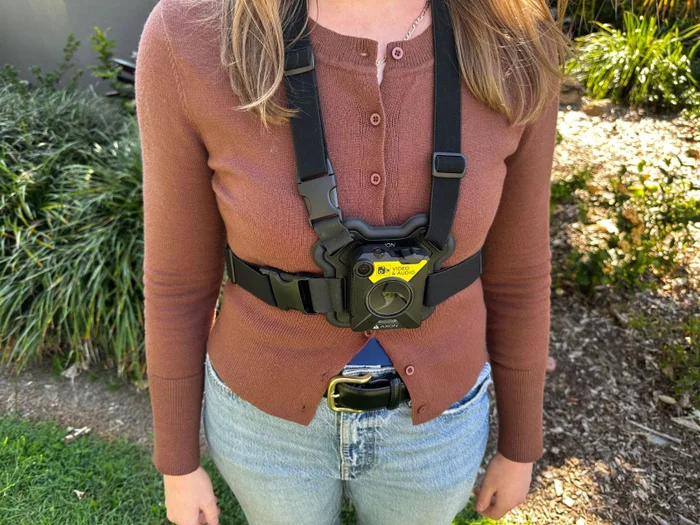 An unidentified person, with only the torso in frame, wearing a bodycam.