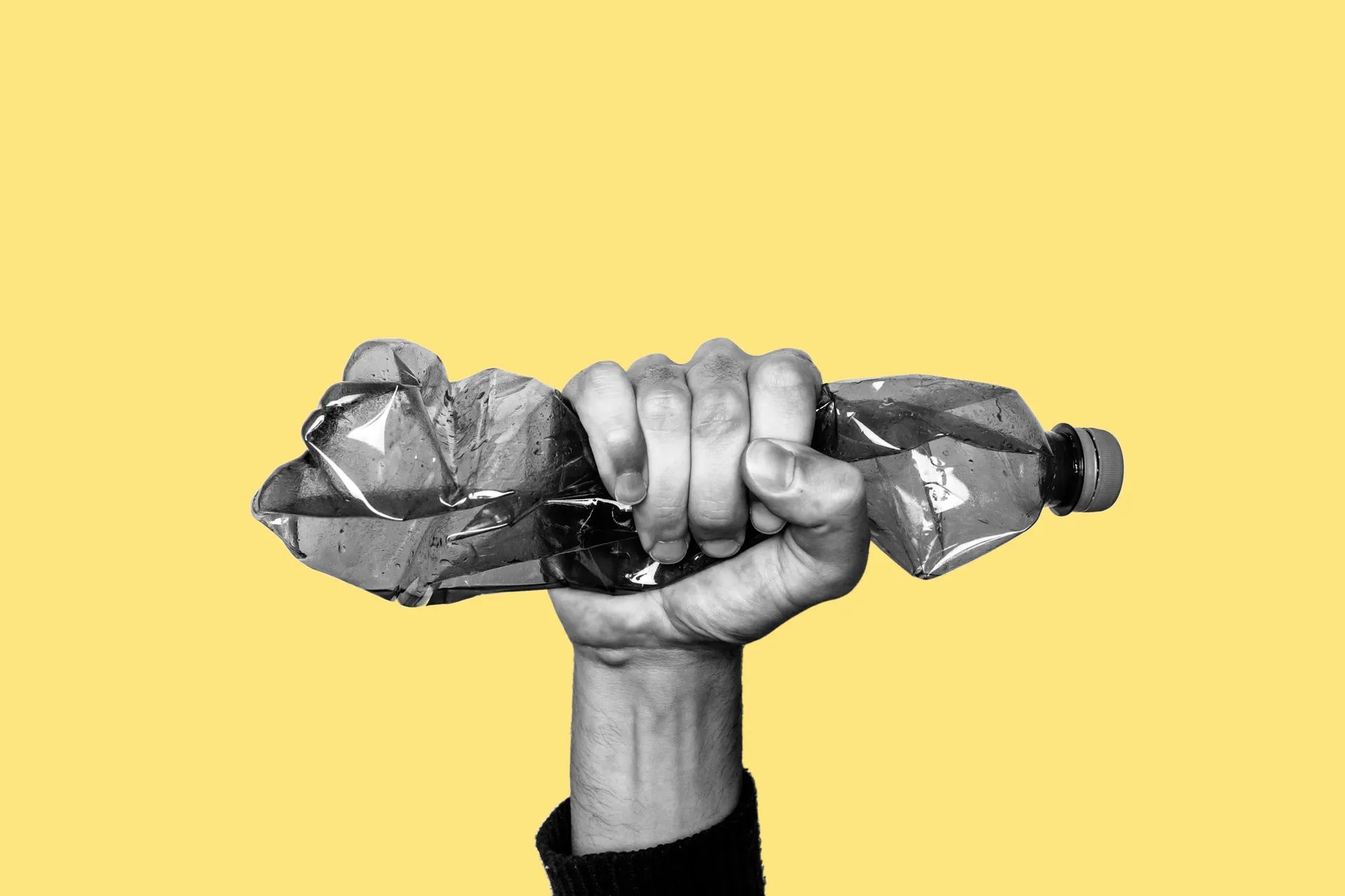 hand squashing a plastic bottle