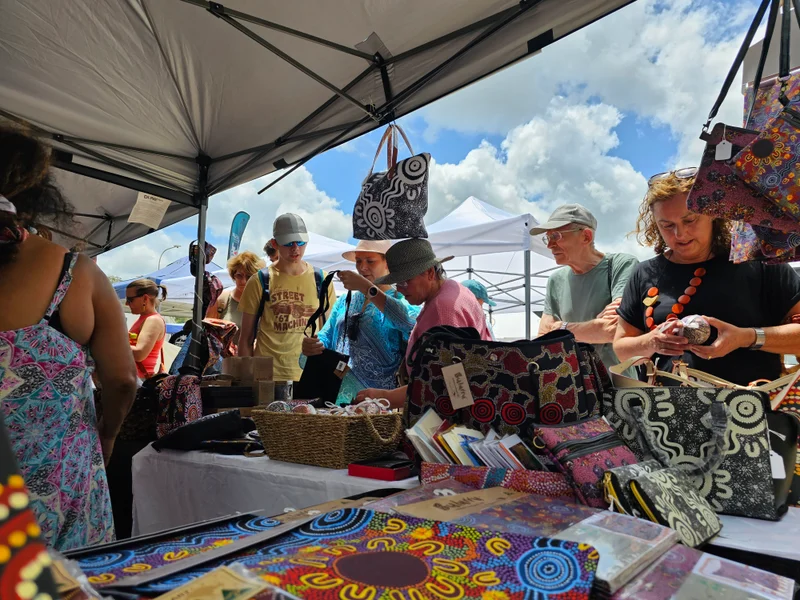 Crowds browse a market stall.
