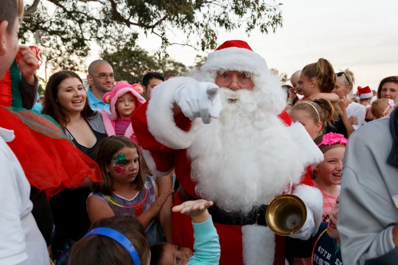 santa in a crowd pointing at the viewer