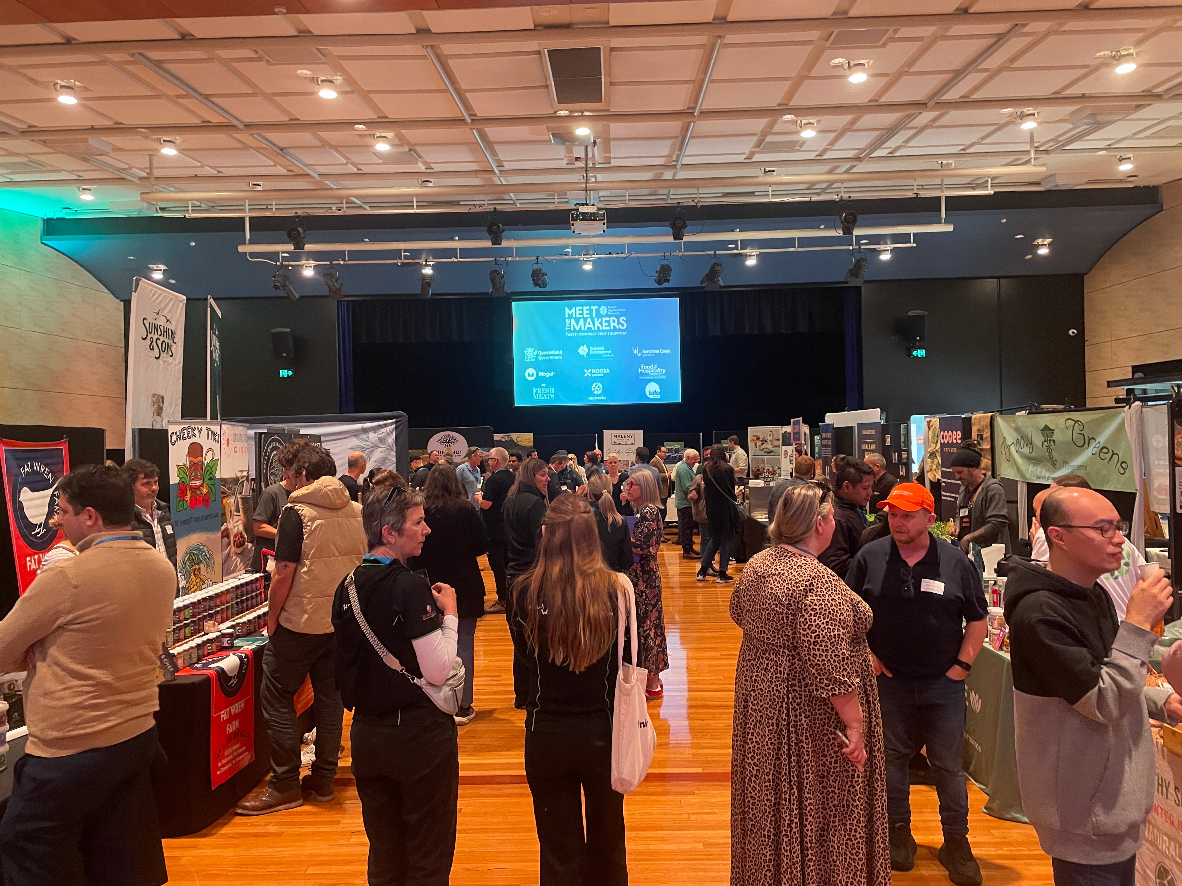 Crowd shot of Meet the Makers 2026 event - stallholders on both sides of a walkway