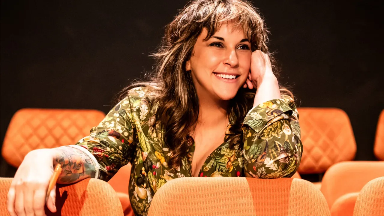Bec Martin sitting in a theatre with orange seats